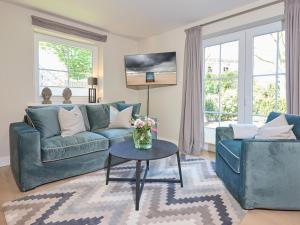 韦斯特兰Appartement Krabbe的客厅里有两张蓝色沙发和一张桌子。