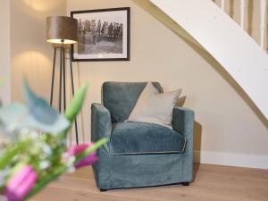 a green chair in a living room with a lamp at Appartement Krabbe in Westerland (Sylt)