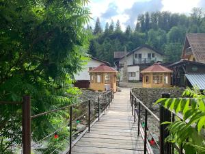 a wooden walkway in a village with houses at Podul De Brazi in Cîrţişoara