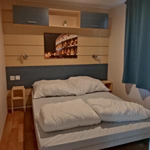 een bed in een slaapkamer met een muur met een tv bij Smart Home Roma mit Terrasse, Europapark, Rulantica in Boofzheim +31 foto's