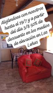 a red couch in a living room with a sign at COMPLEJO STYLE,CENTRICO,MUY SEGUR in Malargüe