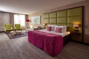 a hotel room with a large bed and a living room at Hotel van der Valk Wolvega-Heerenveen in Wolvega +69 photos
