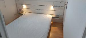a small bedroom with a bed with lights on it at Appartement proche mer in Cucq
