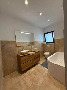 a bathroom with two sinks and a tub and a toilet at Chez Claudine & Adrien in Figari +19 photos