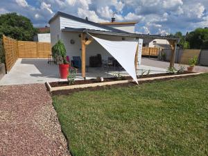 a patio with a white tent in a yard at Maison Halle in Pouxeux