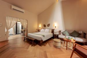 a bedroom with a bed and a couch at La Sen Village in Ninh Binh