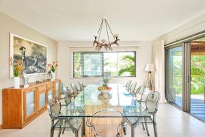 een eetkamer met een glazen tafel en stoelen bij SG17 Villa Sable Front de Mer in Palmar