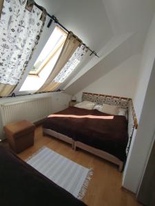 a attic bedroom with two beds and a window at Chata Holica PIENINY in Lesnica +49 photos