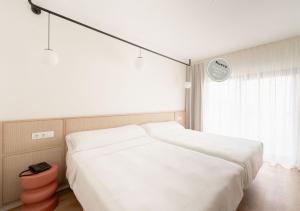a bedroom with a large white bed and a window at Hotel RH Arena - Todo Incluido in Gandía