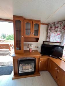 a kitchen with a microwave and a stove at Domek Czapla in Stare Sady