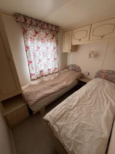 a small room with two beds and a window at Domek Czapla in Stare Sady