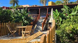 un patio avec des chaises et une table et une maison dans l'établissement Casa Rural Tía Rita La Gomera, à Vallehermoso