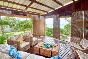 sala de estar con sofá y sillas en el porche en SG17 Villa Sable Front de Mer, en Palmar