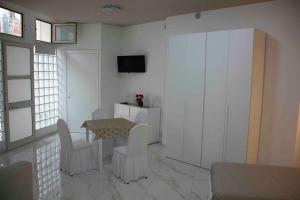 a living room with a table and chairs and a tv at Angela's dreams in Conversano