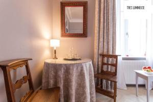 a room with a table with a lamp and two chairs at Alouette in Colmar