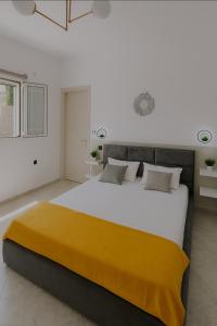 a bedroom with a large bed with a yellow blanket on it at Endless Green Villa in Argostoli