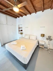 a bedroom with a large bed with a wooden ceiling at Traditional Mykonian House in Mikonos +5 photos