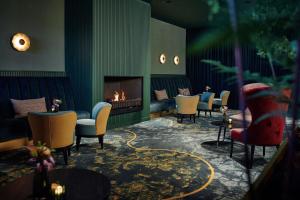 a living room with a fireplace and chairs at Hotel van der Valk Wolvega-Heerenveen in Wolvega