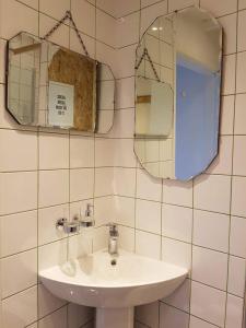 a bathroom with a sink and a mirror at Grain Store Cottage in Narberth +28 photos