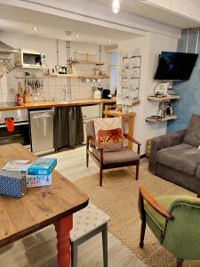 a living room with a table and a kitchen at Farmhand Cottage in Narberth