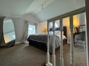 a bedroom with a bed and a mirror at Abbey View Coach House in Youghal