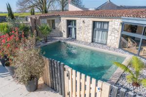 a swimming pool in front of a house at Gîte Lunaben-Maison en pierres avec piscine in Forges