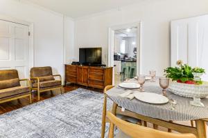 a dining room with a table with chairs and a television at 1 Mi to Needham Center Square: Pet-Friendly Apt! in Needham Heights