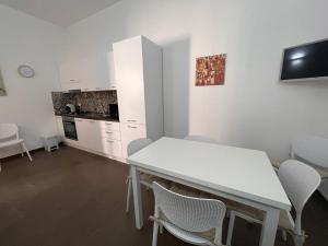 a white kitchen with a white table and chairs at Casa Camillo via Camillo Benso di Cavour n 63bis in Avola