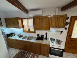 a kitchen with wooden cabinets and a sink and a stove at Socros Home, Mesta Chios in Mestá
