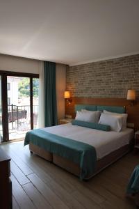 a bedroom with a large bed and a brick wall at Sardinia Otel in Amasra