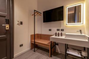 a bathroom with a sink and a tv on the wall at Up Central Córdoba in Buenos Aires