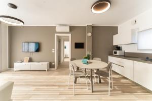 a kitchen and dining room with a table and chairs at Sun Beach Residence con Piscina - Piazza Brescia - Adria Holiday Jesolo - FAMILY APARTMENTS in Lido di Jesolo