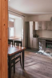 a kitchen with a wooden table and a dining room at Residence Traube in Bressanone +14 photos
