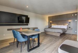 Una habitación de hotel con una cama, una mesa y sillas. en Hôtel-Motel Normandin Alma, en Alma