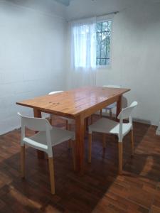 a wooden table with two white chairs around it at Cabaña "Bienestar" vista a las sierras, cerca del rio en La Serranita in Alta Gracia +2 photos