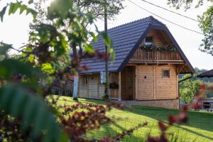 a wooden house with a balcony and a yard at Brvnara Oganj in Čajetina