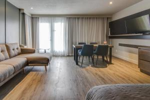Una sala de estar con un sofá y una mesa con sillas. en Hôtel-Motel Normandin Alma, en Alma