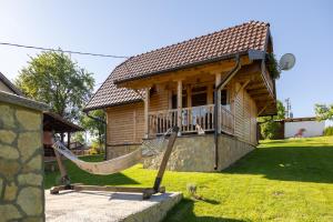 a house with a hammock in front of it at Brvnara Oganj in Čajetina