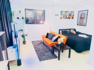 a bedroom with a bed and a orange couch at Smart Artistic studio in shoreditch in Moffat