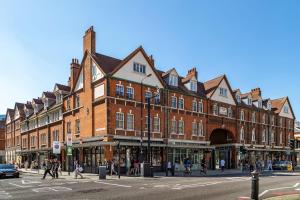a large brick building on a street with people crossing the street at Smart Artistic studio in shoreditch in Moffat