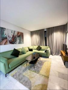 卡萨布兰卡A102 Studio cosy & chic的客厅里有一张绿色的沙发和一张桌子