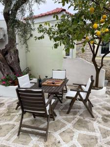 a picnic table and two chairs and a tree at Mediterranean house in Skala Sotiros