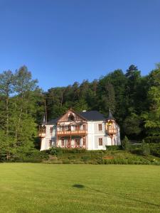 a large house sitting on top of a lush green field at Pozlovice - Apartmán Sisi in Luhačovice