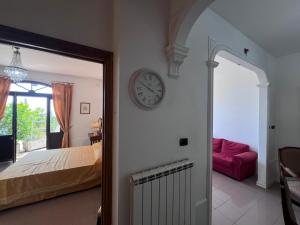 a bedroom with a bed and a clock on the wall at Villa vista mare in Varazze