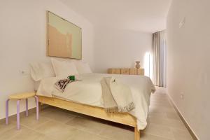 a white bedroom with a large bed and a stool at Kokomo beachfront in Cotillo +37 photos