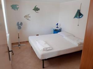 a white bed in a room with butterflies on the wall at Nuovo AliRu in Campofelice di Roccella
