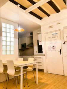 a dining room with a white table and chairs at Nice apartment in the middle of Born in Barcelona