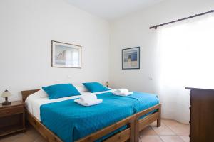 Un dormitorio con una cama con sábanas azules y blancas. en Sunset Retreat Villa Sophia, en Posidhonía