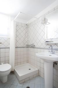 Un baño blanco con inodoro y lavabo. en Sunset Retreat Villa Sophia, en Posidhonía
