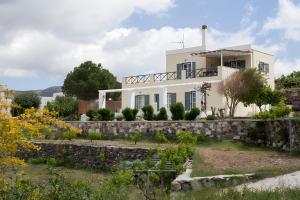 una casa blanca con un muro de piedra en Sunset Retreat Villa Sophia, en Posidhonía